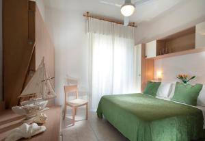 里米尼费利克斯酒店 的一间卧室配有绿色的床和椅子