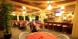 波尔多·格尼拉潜水中心美人鱼度假村的一间带桌椅的餐厅和一间酒吧