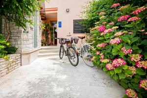 罗维尼Vila Dolores的两辆自行车停在一座鲜花盛开的建筑旁边