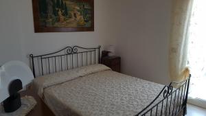 滨海波利尼亚诺Villa Mancini - Locazione turistica的卧室配有一张床,墙上挂着一幅画