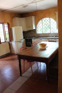 佛罗伦萨La Cascianella的厨房配有木桌和冰箱。
