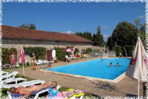 Bonnac-la-Côte雷克易喜尔德普莱户外露营旅馆的大型游泳池,人们躺在草坪上