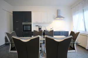 扎达尔Apartments Zelic的厨房配有餐桌和椅子