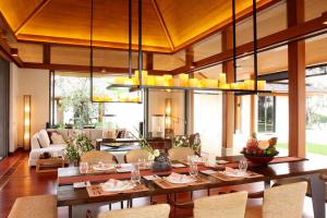 纳泰海滩Villa Sundara - SHA Extra Plus的用餐室配有大型木桌和椅子