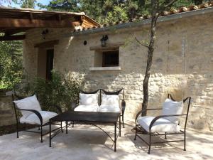 蒙布兰莱班B&B Le Deffends de Redon的庭院配有四把椅子、桌子和枕头
