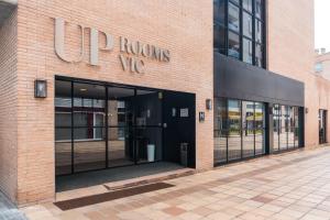 维克Up Rooms Vic Hotel的前方有建筑物入口的商店