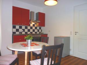 耶拿City Apartment Jena的厨房配有桌椅和红色橱柜