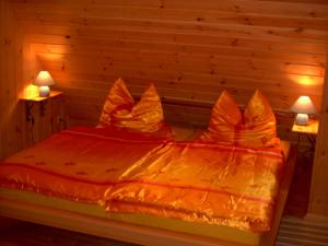 LeopoldshagenFerien auf dem Lande的一张带橙色棉被和两盏灯的床