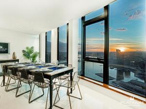 墨尔本Platinum Luxury Stays at The Victoria Rooftop Penthouse的一间带桌椅和大窗户的用餐室