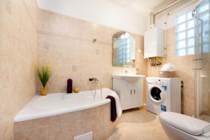 布达佩斯Grand Budapest Penthouse的带浴缸和洗衣机的浴室。