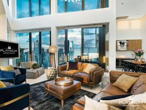 墨尔本Platinum Luxury Stays at The Victoria Rooftop Penthouse的一间客厅,配有皮革家具,享有城市美景
