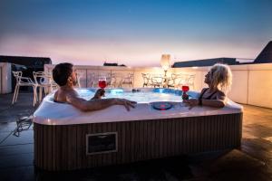 维罗纳科特昂迦若酒店的两人在热水浴缸中享用一杯葡萄酒