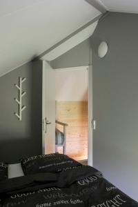 福尔特赫伊曾Camping Nieuw Romalo的一间卧室配有一张床,一扇门通往一个房间