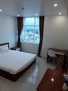 金瓯Sao Kim的一间卧室配有一张床、一张书桌和一个窗户。