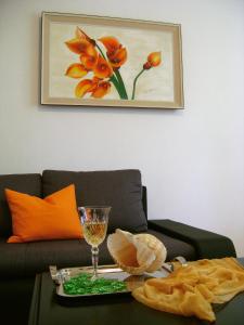 斯普利特Apartment Veronica的客厅配有沙发和带葡萄酒玻璃的桌子