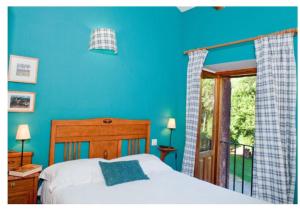 Villacorta莫利诺德拉费雷里亚酒店的一间蓝色卧室,配有一张床和一个阳台