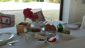 阿尔塔穆拉Masseria Colle Carro BA07200451000019667的一张桌子,上面有白色的桌布,上面有食物