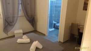 莱波拉诺Villa Satyria B&B的一间设有床铺的房间,上面有两条毛巾