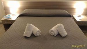 莱波拉诺Villa Satyria B&B的床上有两条毛巾,有两张桌子