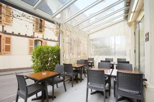 日内瓦卡勒威酒店的餐厅内带桌椅的庭院