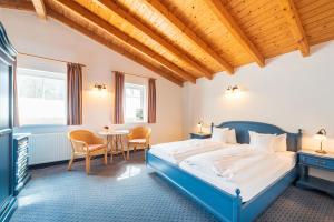 宾茨加尔尼艾卡酒店的一间卧室配有一张蓝色的床和一张桌子