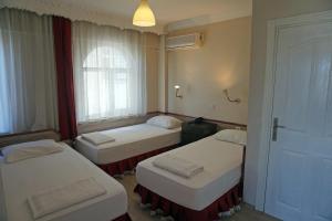 埃杰阿巴德波斯酒店的带三张床和窗户的客房