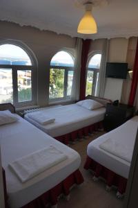 埃杰阿巴德波斯酒店的带三扇窗户的客房内的三张床