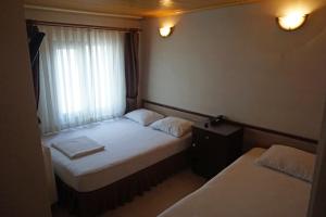 埃杰阿巴德波斯酒店的小房间设有两张床和窗户
