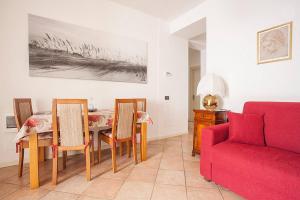 克雷莫纳Residenza "Il Torrazzo"的客厅配有红色的沙发、桌子和椅子