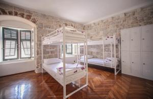 杜布罗夫尼克安吉丽娜老城旅舍的带两张双层床和砖墙的客房