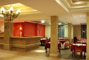 瓜伊马延Hotel Savoia Mendoza的餐厅拥有红色的墙壁和桌椅
