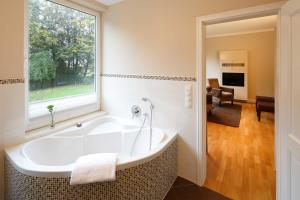 基尔基尔考夫曼罗曼蒂克酒店的带浴缸的浴室和窗户