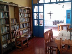 塔斯科·德·阿拉尔孔圣普里斯卡酒店的藏书架的图书馆,书架上摆放着书籍和桌子