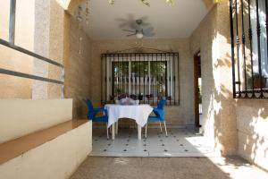 卡沃内拉斯MOLINO 7的庭院配有白色的桌子和蓝色的椅子