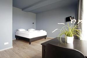 雷克雅未克Iceland Comfort Apartments by Heimaleiga的一间卧室配有一张床和一张植物桌子