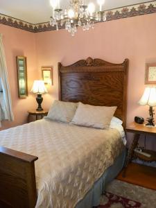 CaribouOld Iron Inn Bed and Breakfast的一间卧室配有一张大床和木制床头板