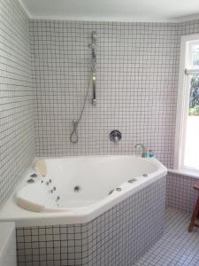 奥波蒂基Ohiwa Seascape Studios的瓷砖浴室设有白色浴缸。
