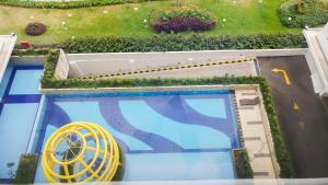 雅加达Simple Studio Bassura City Apartment By Travelio的游泳池的顶部景,黄色