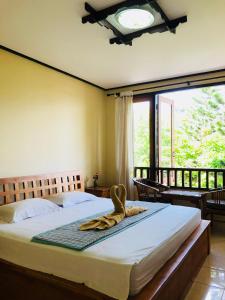 八丹拜Padangbai Beach inn的一间卧室设有一张床和一个大窗户