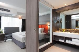 曼谷Grand 5 Hotel & Plaza Sukhumvit Bangkok的酒店客房设有床、浴缸和水槽