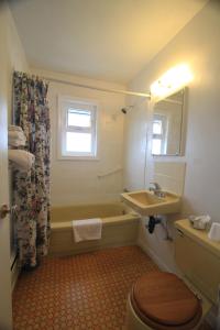 艾伯尼港日落汽车旅馆的带浴缸、盥洗盆和卫生间的浴室