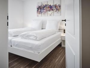 鲁斯特Villa Elsa的卧室设有两张床,拥有白色的墙壁和木地板