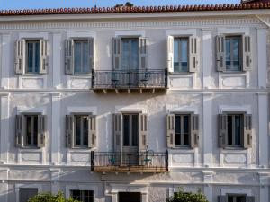 纳夫普利翁Gambello Luxury Rooms的白色建筑的外墙,带有窗户