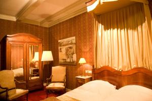 福伦霍弗Stadspaleis Hotel & Restaurant OldRuitenborgh的一间卧室配有一张床、一把椅子和一个梳妆台