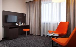 下塔吉尔Demidov Plaza的酒店客房设有橙色椅子和电视