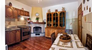 冈多菲堡Villalbert的厨房配有木制橱柜、桌子和壁炉。