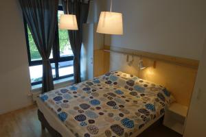 塔尔图Raua 15 Apartment的卧室内的一张床位,配有两盏灯和一扇窗户