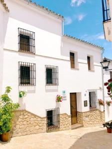 埃尔加斯托尔马德罗内拉度假屋的白色的建筑,设有黑色的窗户和门