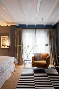 阿姆斯特丹suite no 7的卧室配有床、椅子和窗户。
