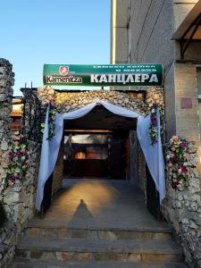 KaspichanKanclera Hotel的一座带拱门和鲜花的建筑的入口